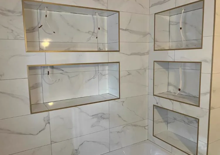 Marble-effect large format bathroom tiles with gold-trim recessed shelving niches, Banks and Co Ceramics luxury wet room