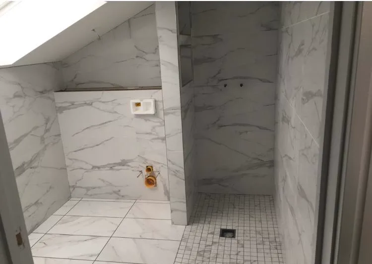 Marble-effect loft wet room conversion with floor-to-ceiling large format porcelain tiles, Banks and Co Ceramics