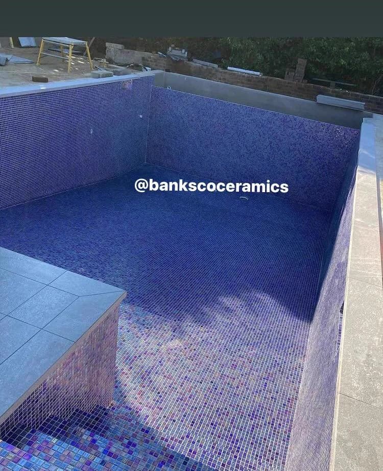 Blue and purple iridescent glass mosaic tiles lining a residential swimming pool