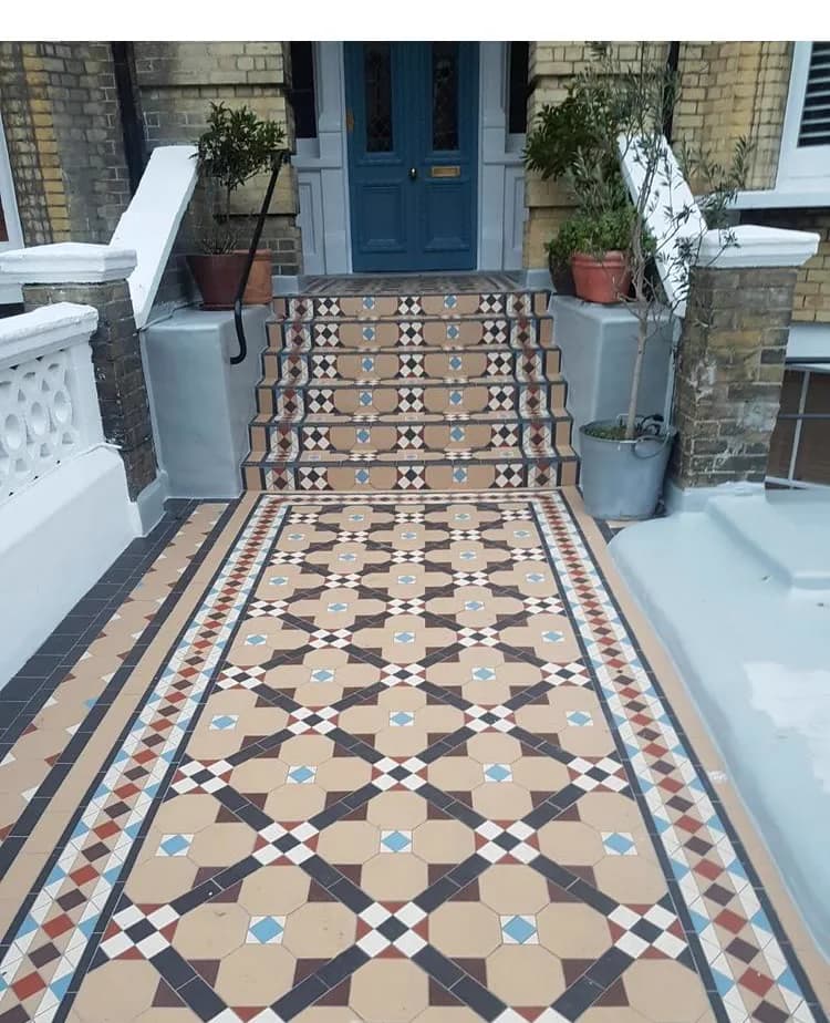 Colourful geometric mosaic garden path and steps in blue, terracotta and cream at a period Sussex villa